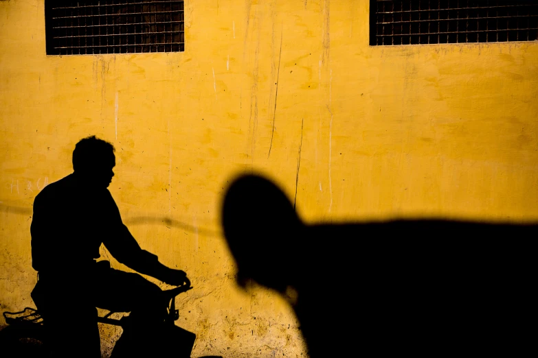 a shadow of a man riding a bike in the dark