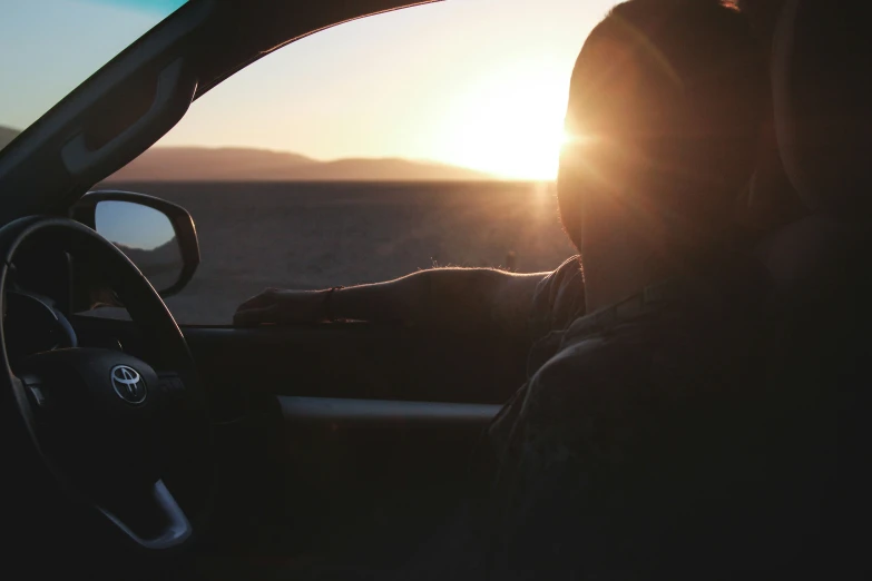 the sun rising in front of the dashboard of a car