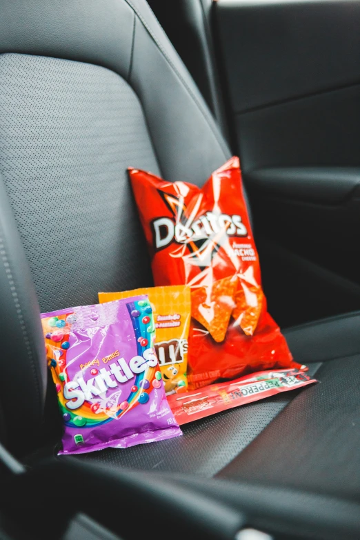 two small chips are next to a cushion in the car