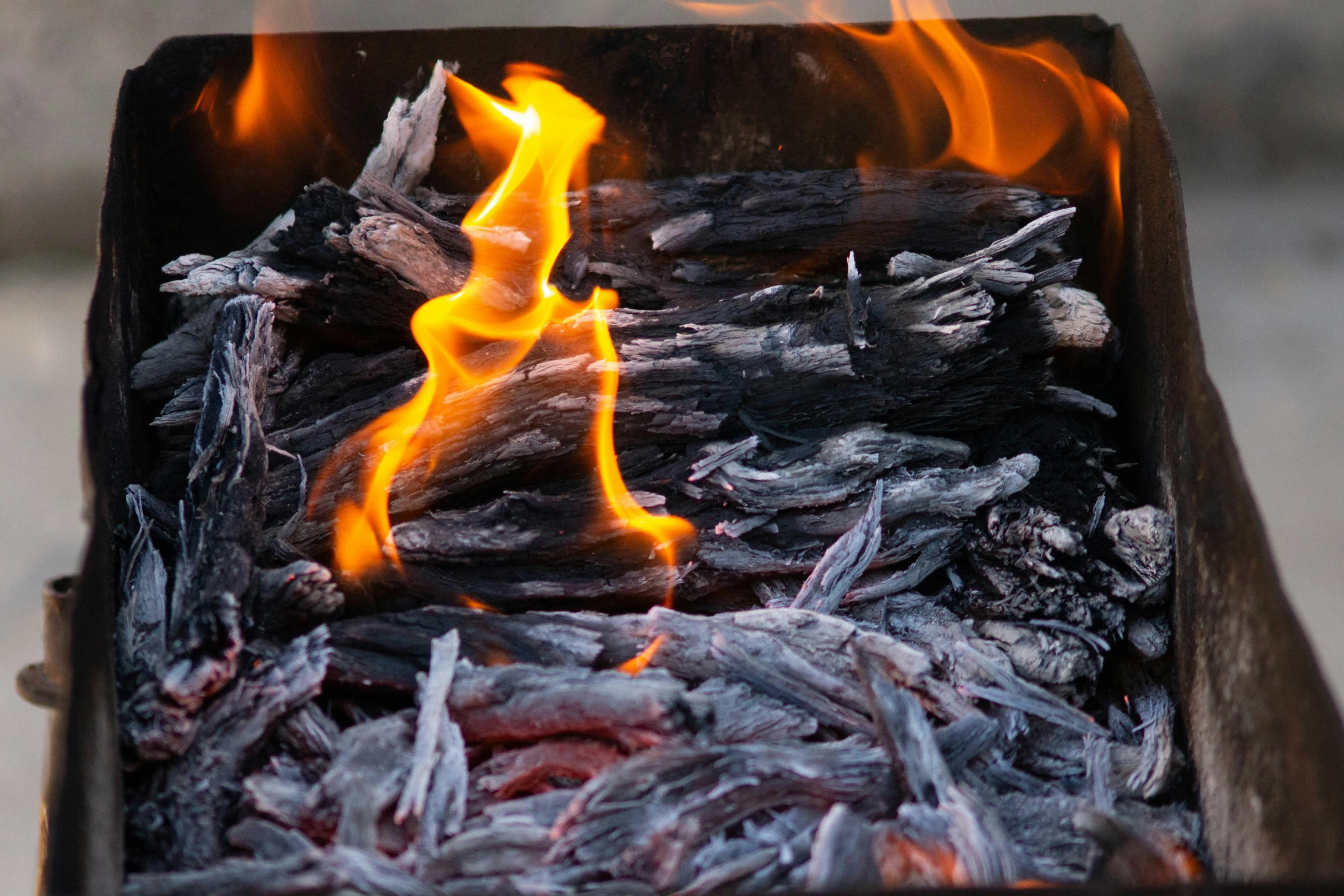 a grill with  coal next to fire