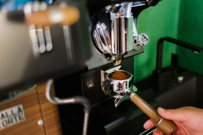 someone using a wooden stick to operate a coffee maker