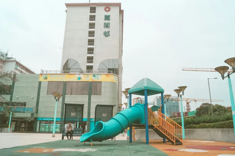 a large playground has a blue slide in front of it