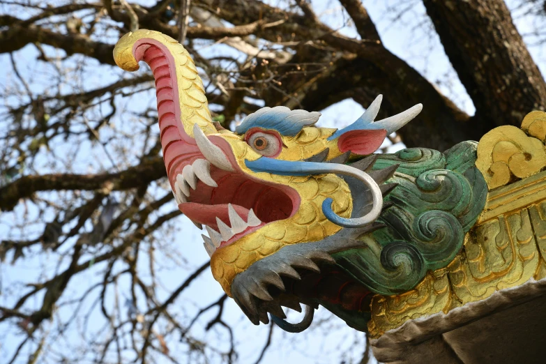 the dragon statue has a huge tail and mouth