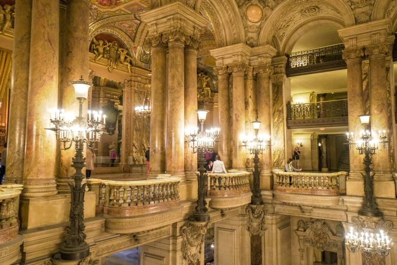 two people sitting on the balcony with ornate columns