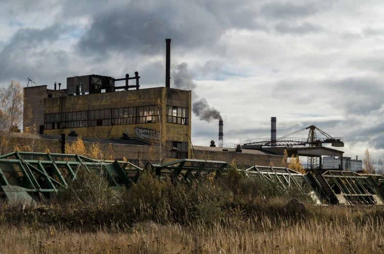 a steam engine and factory is moving through the open field