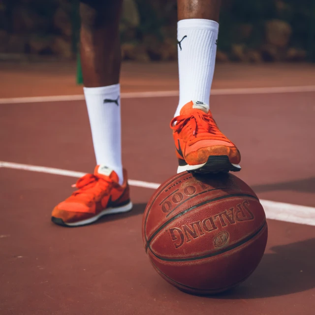 the legs of a basketball player and a ball on the court