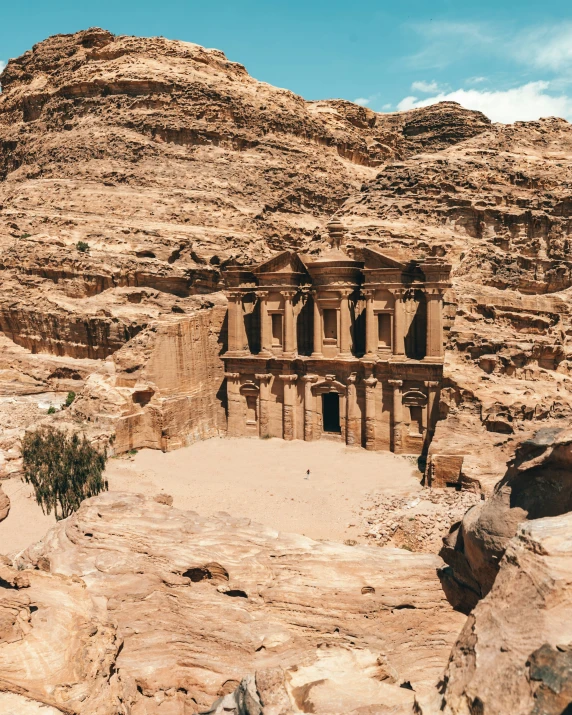 a desert landscape with rocks and a small building in the middle of it