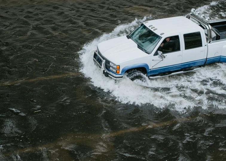 an suv is on top of a large body of water