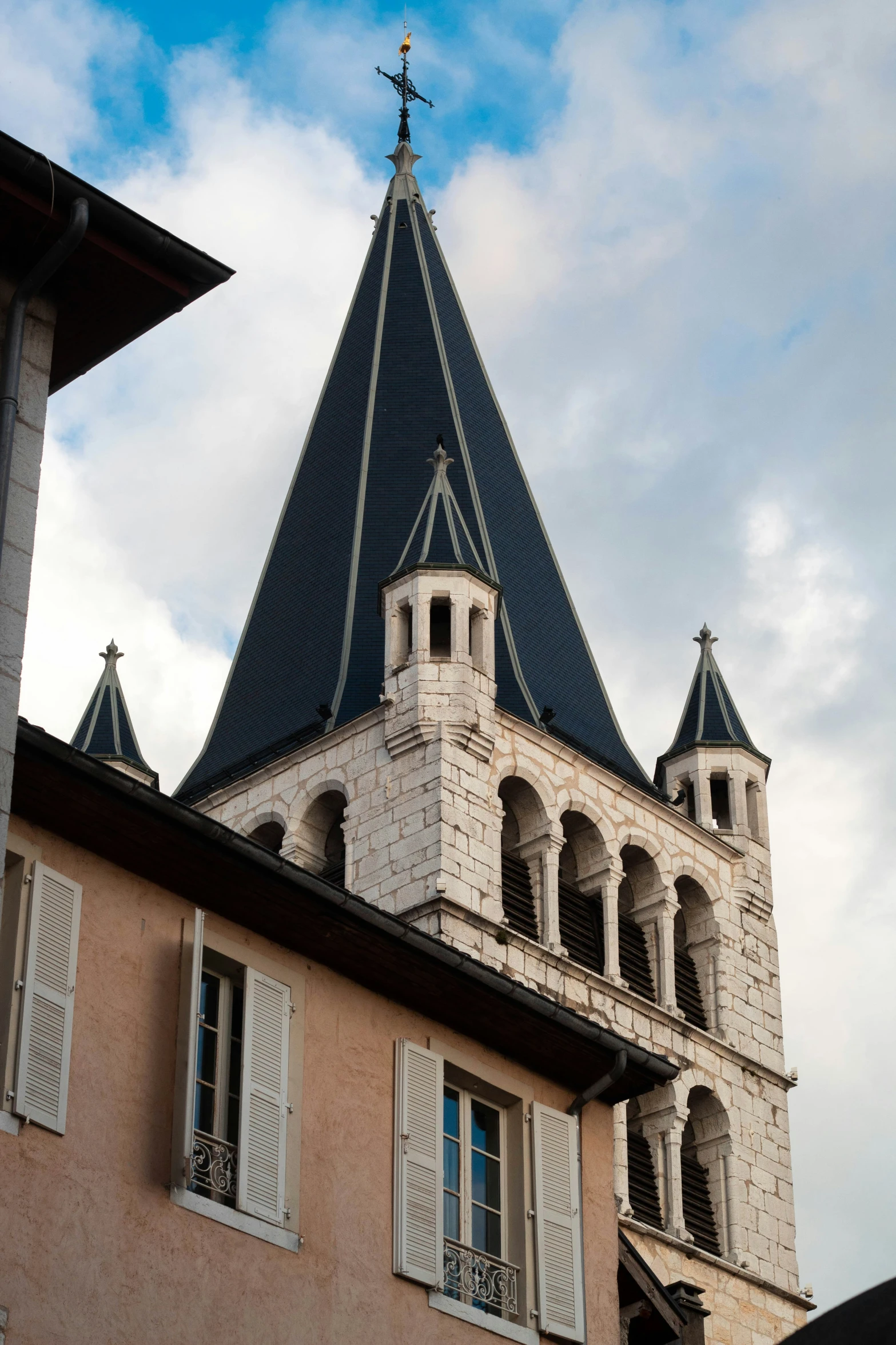 a view of an elegant, tall church steeple with two cupolaes