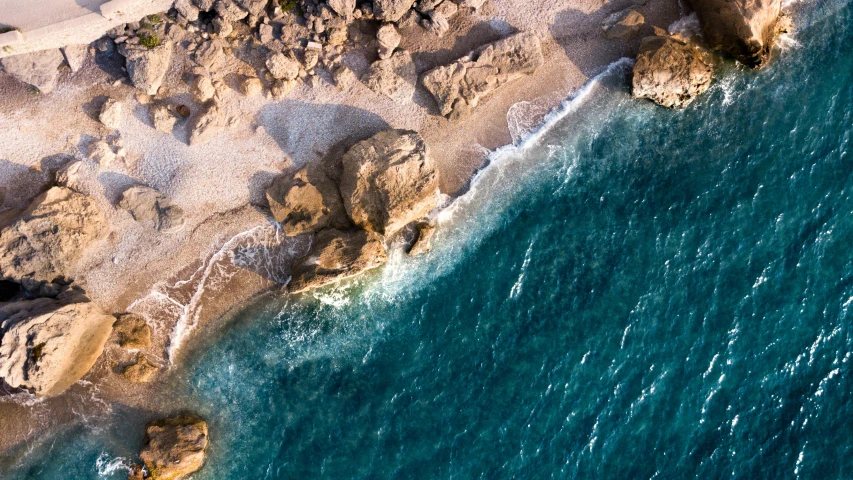 an aerial s of a sandy beach and rocky shoreline