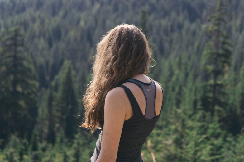 a woman standing in front of pine forest