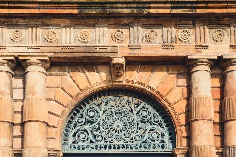 an ornate arched doorway with stone columns and decorative iron work on the door