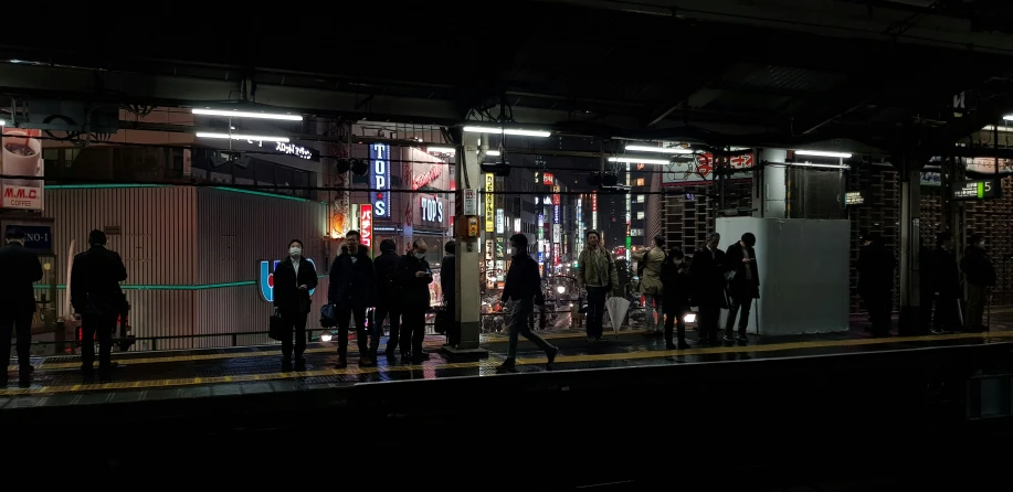 group of people standing at the end of a train track