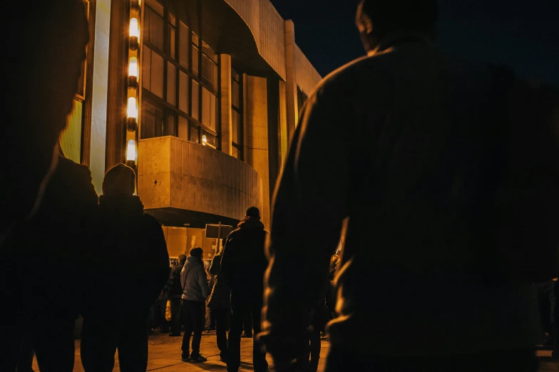 silhouette of people on sidewalk in city at night