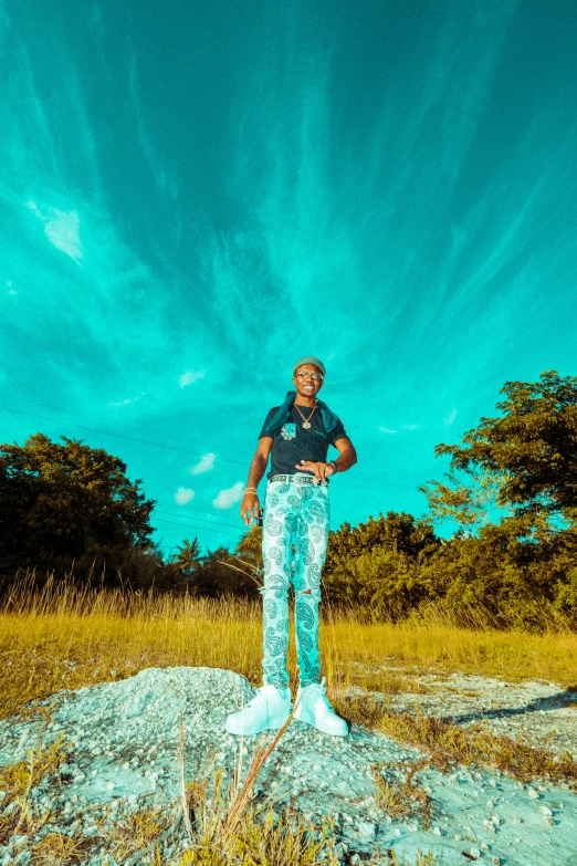 a man with blue pants is standing on a rock