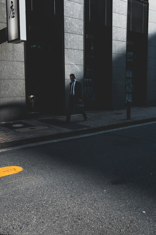 a person walking down a sidewalk next to a building