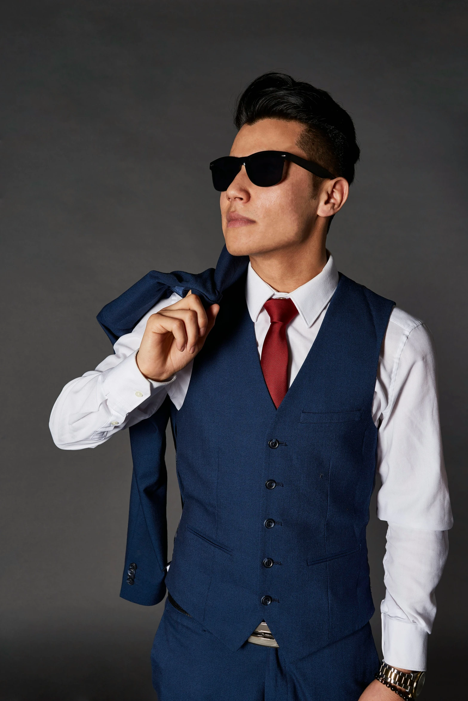 a person in glasses putting on a tie