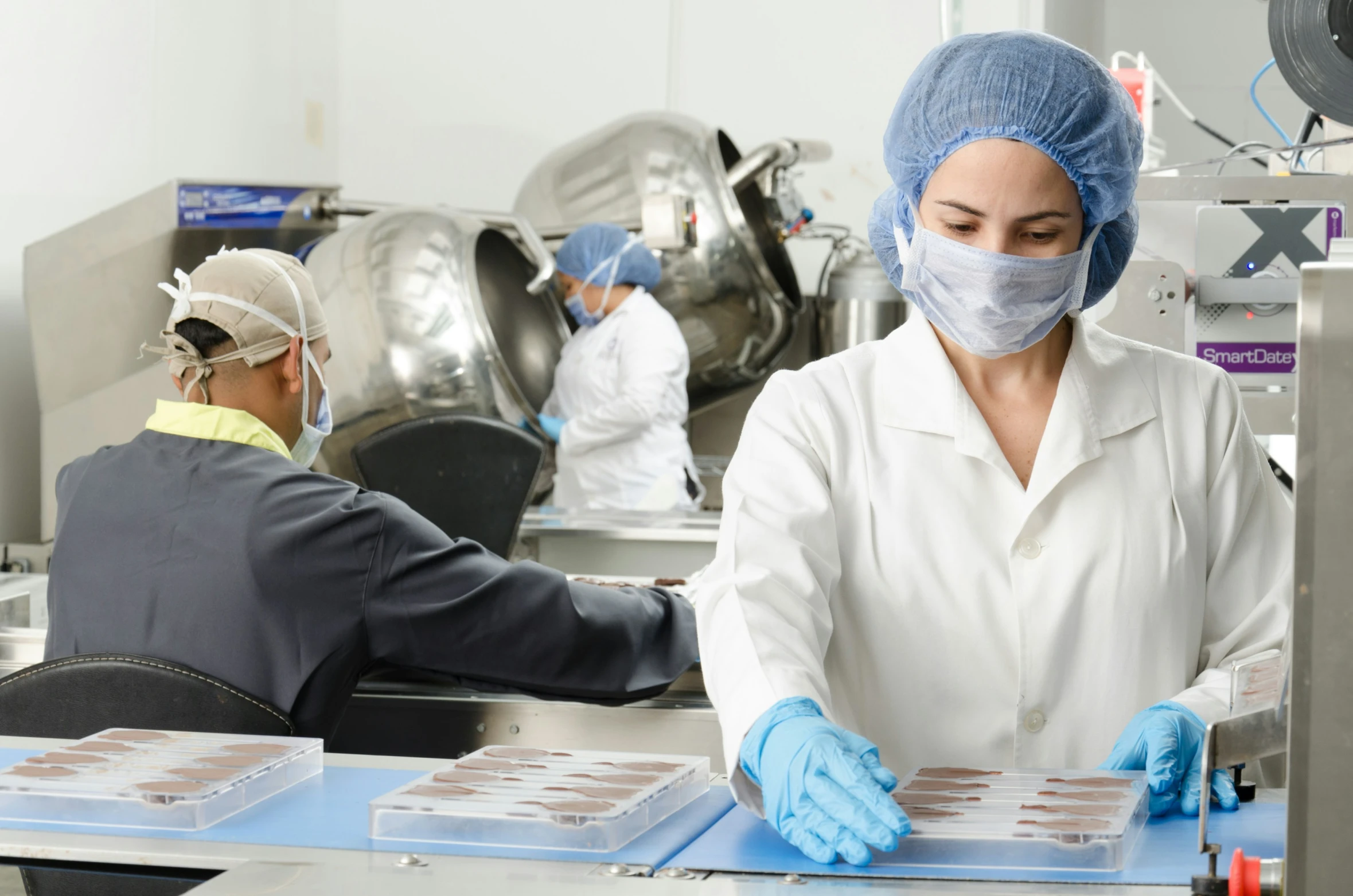 people in a factory working on cookies and making jam