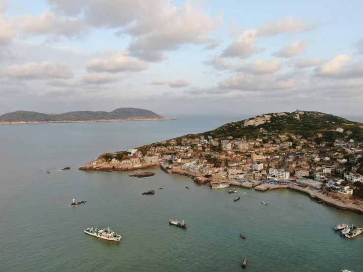 boats floating in a large body of water next to a small island