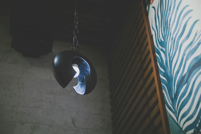 a black metal lamp hangs from a wall