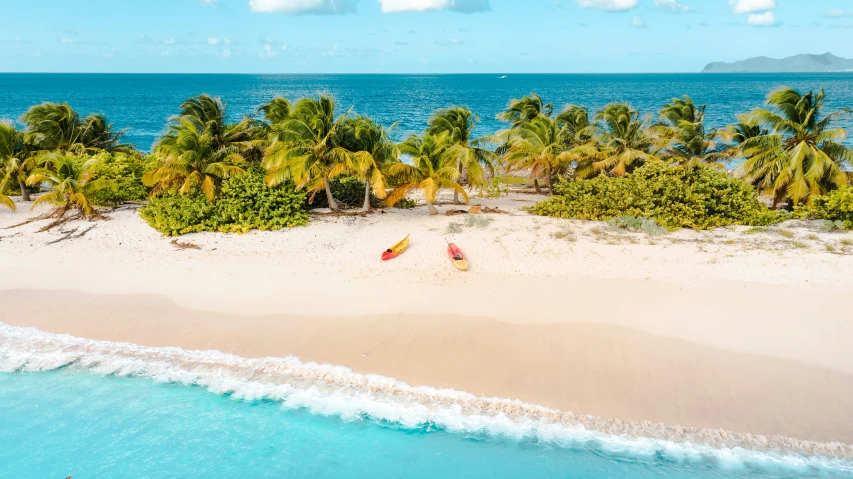 an aerial view of two kayaks in the sand at the beach