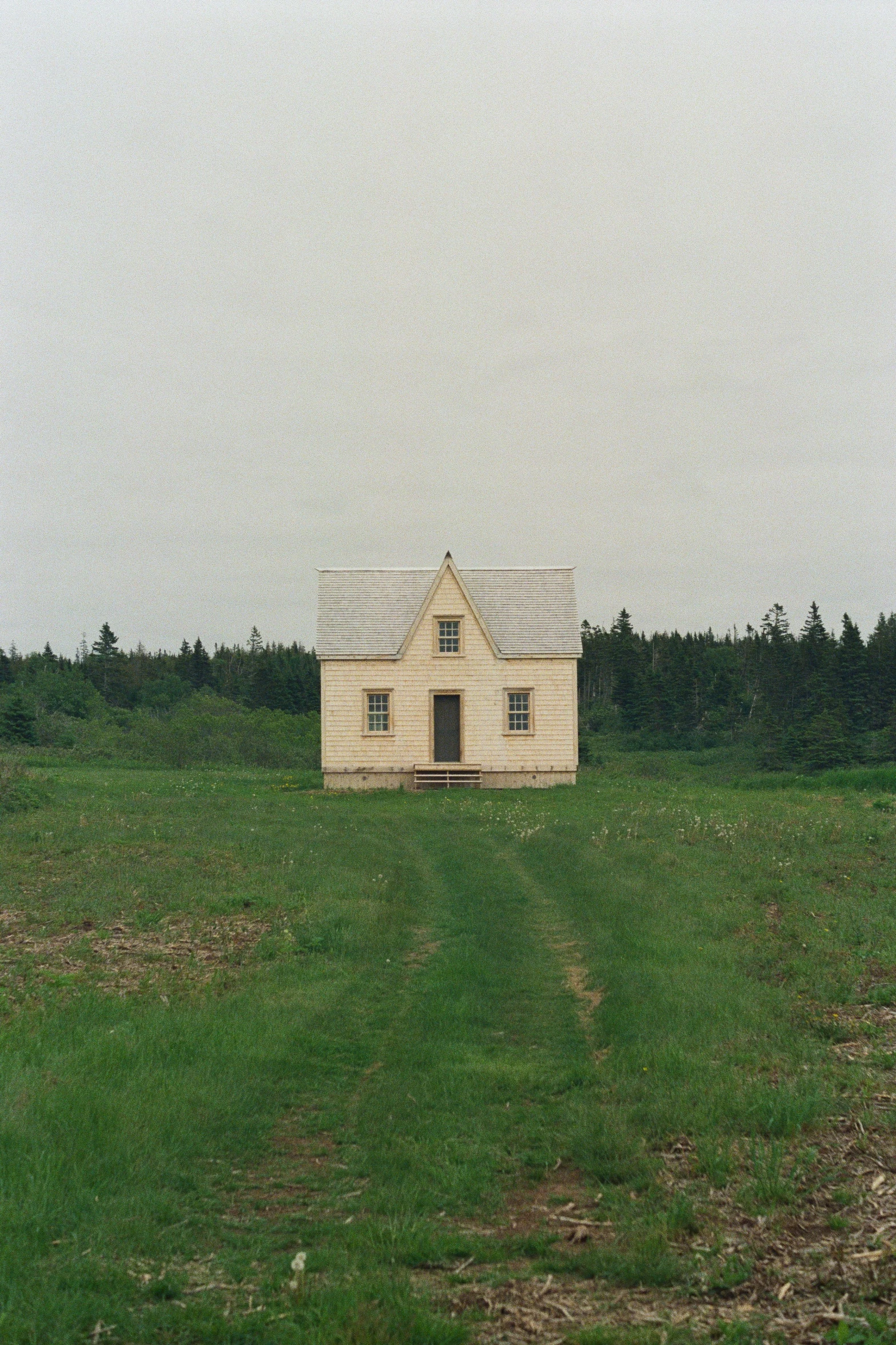 an old house sits on a grassy field