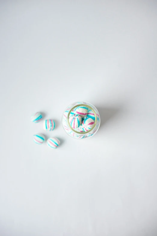 three small candys in a glass container and a sprinkle