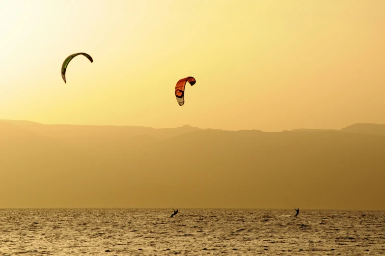 a couple of people on some water with parachutes