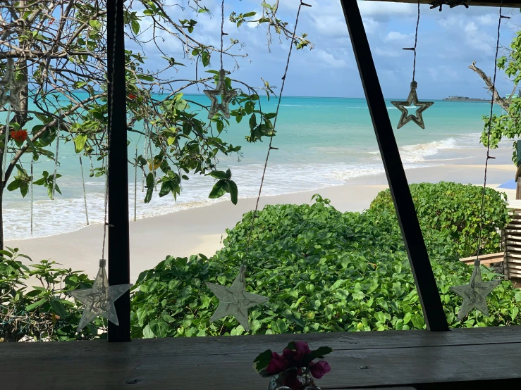 the view from behind a wooden fence onto an empty beach