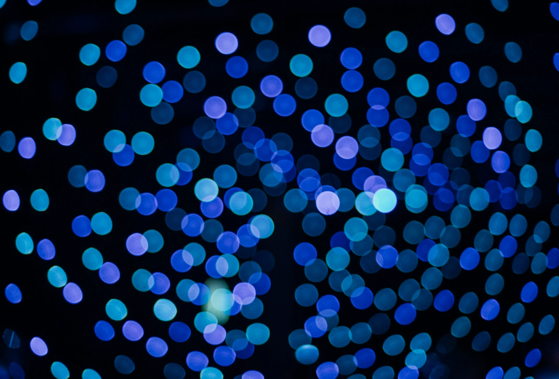 a blue blurry background with tiny circles of light