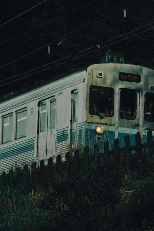 a silver train traveling down tracks next to grass