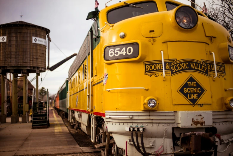 an old yellow train parked at a station