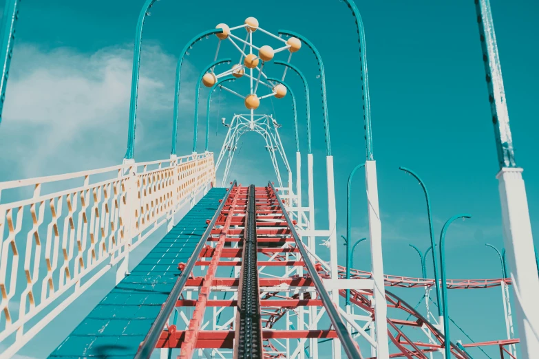 a close up of the top of a tall metal roller coaster