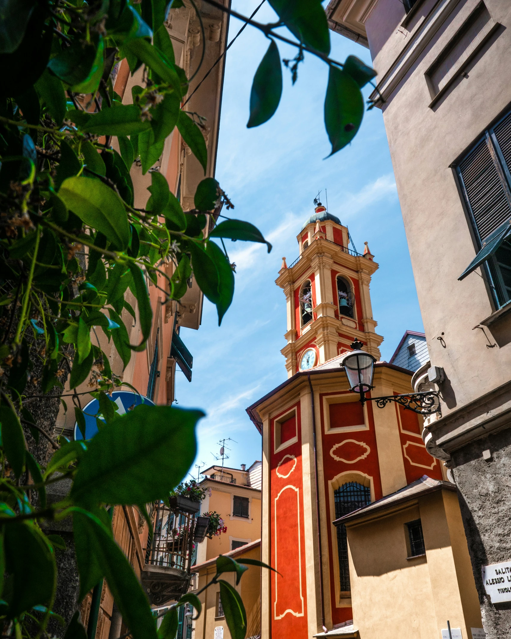 a clock tower with a red face and yellow trim