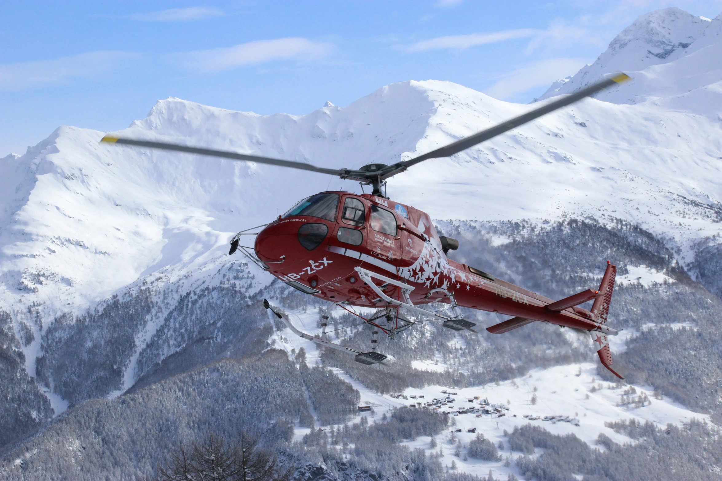 the helicopter is flying over a snowy mountain