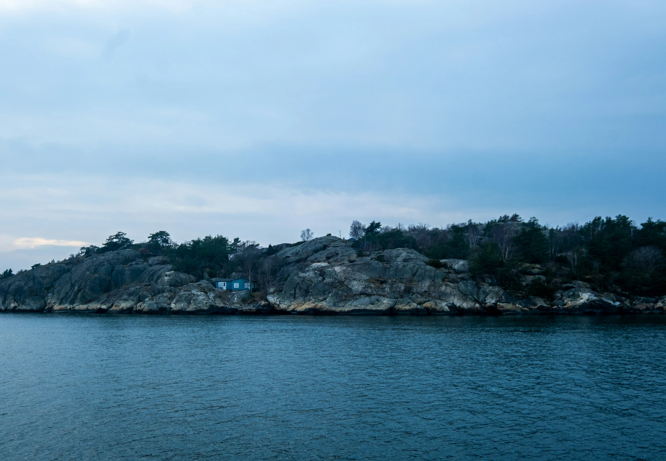 a body of water next to an island on top of a hill