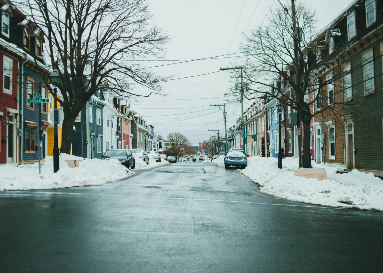 a winter scene of a street and some cars