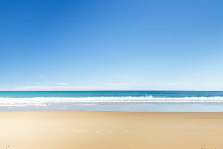 beach view with white waves and bright blue sky