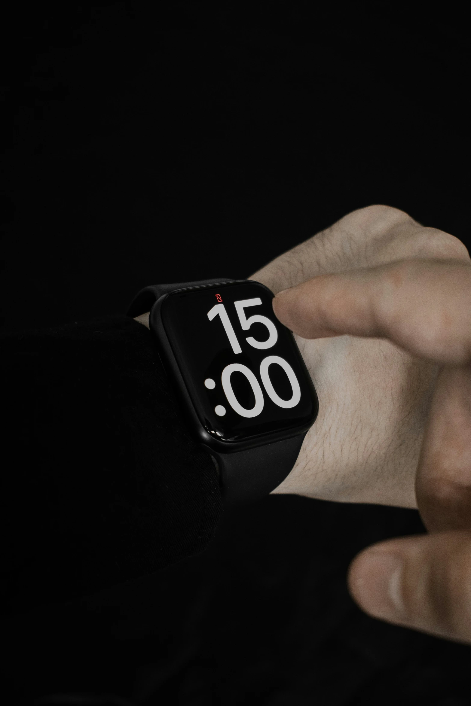 man's hand adjusting watch with black background