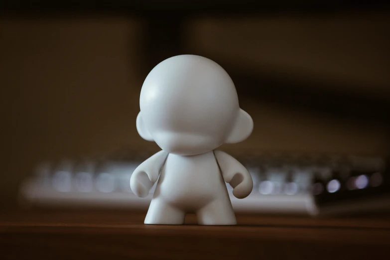 small white sculpture sitting on top of a wooden table