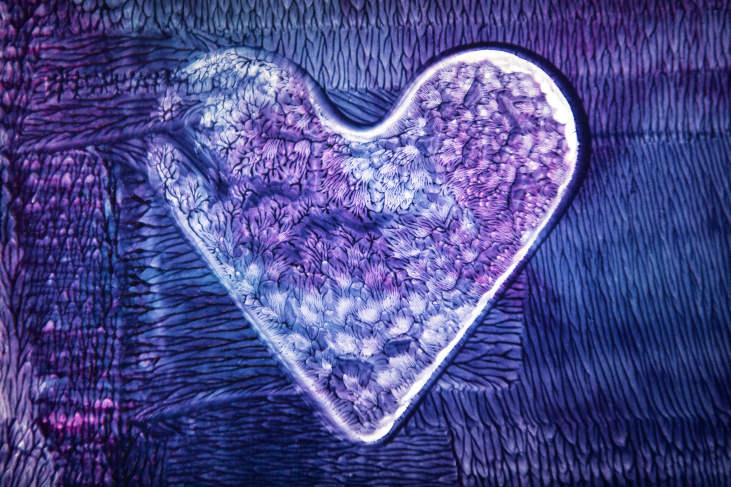 a purple heart shaped object sitting on top of a piece of cloth