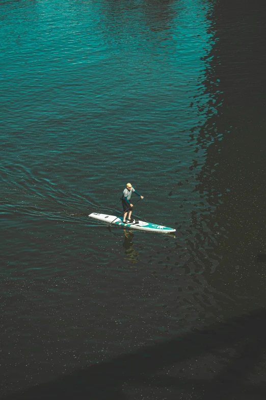 a man standing on a surfboard in a body of water