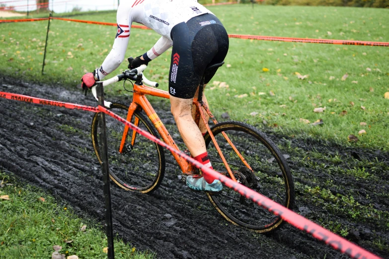 a bicyclist riding a muddy track in a field