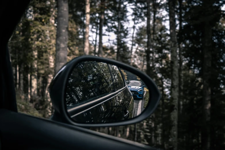 a view in a rearview mirror from the top of a car