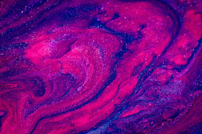 red and purple swirled paint on a dark blue background