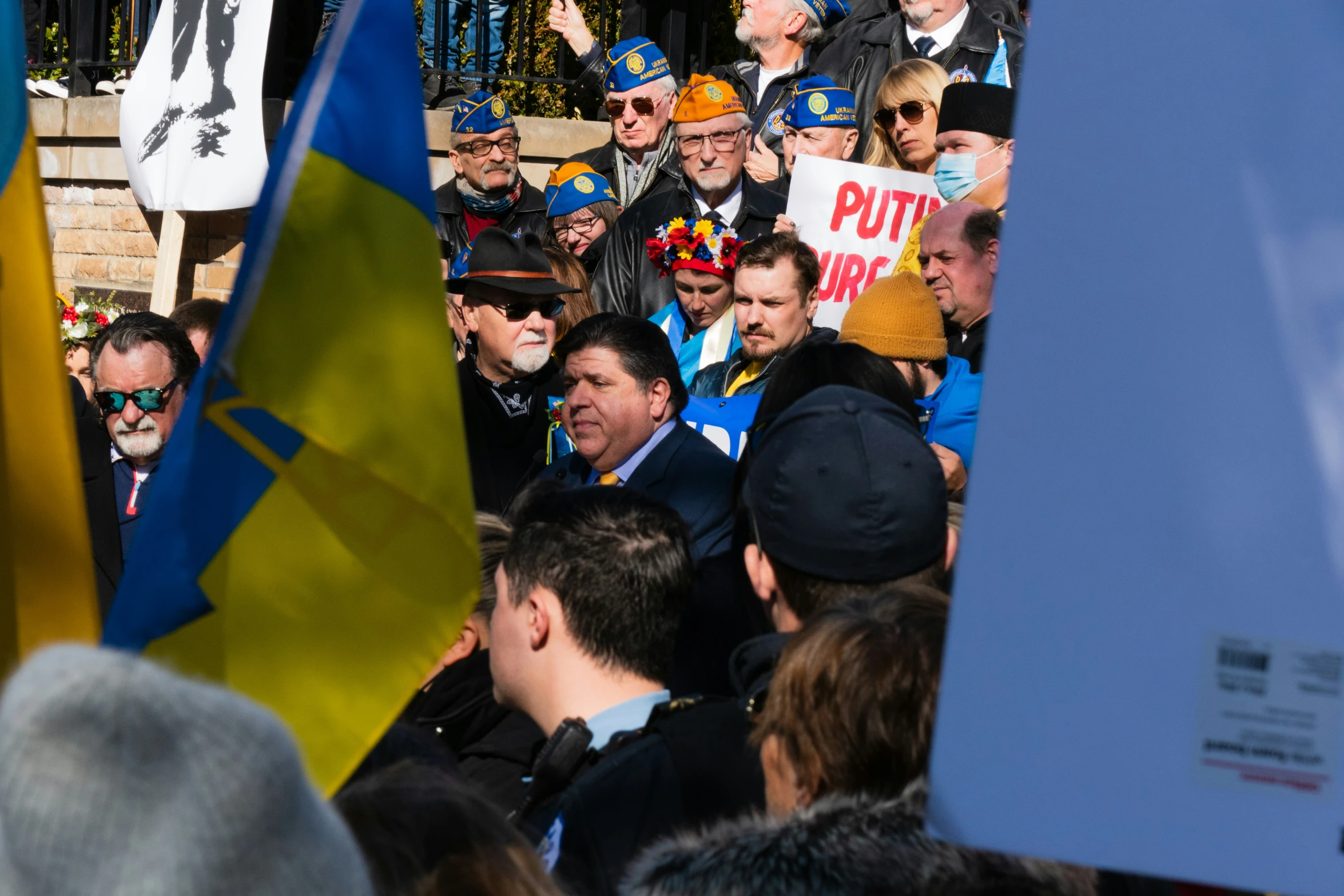 a crowd of people are standing in front of a blue sign