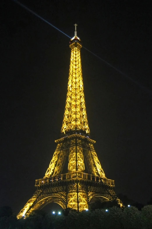 the eiffel tower lit up at night in the sky