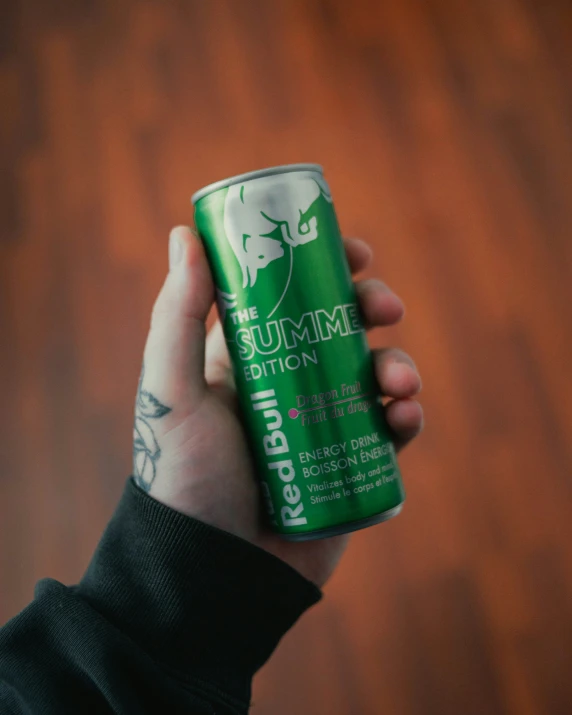 a hand holding a can of red bull summer pitch