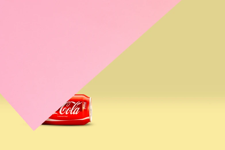 coca cola can lying upside down on a yellow floor