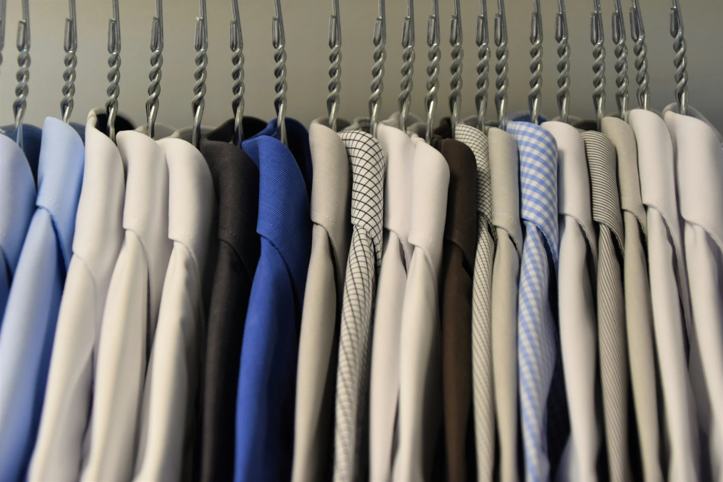 there are many folded shirts hanging on a rack